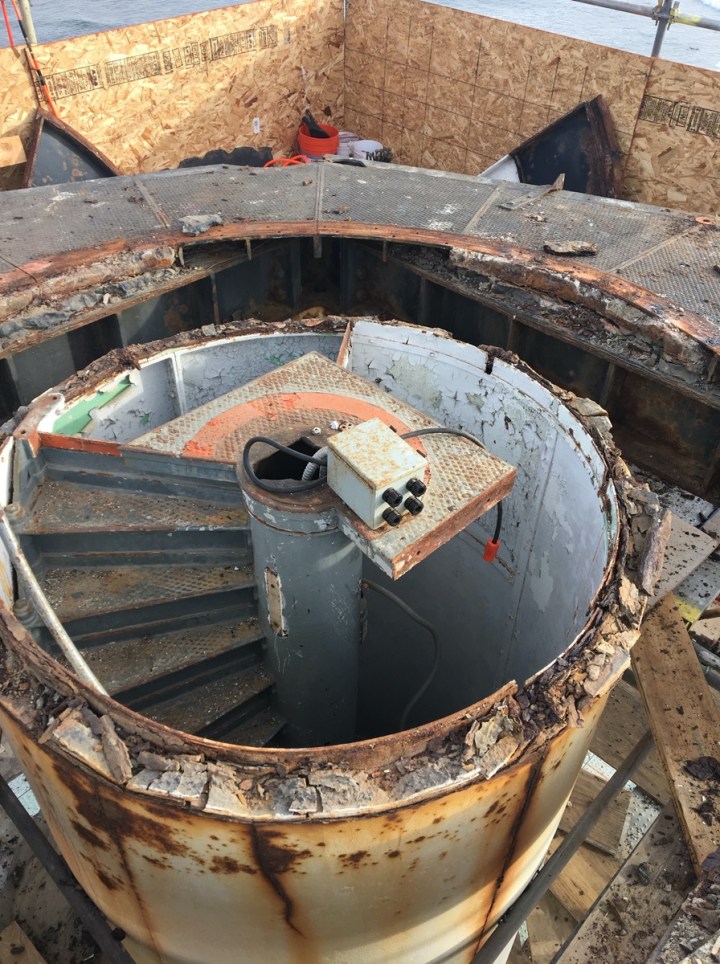 Note the deplorable condition of the central column of the lighthouse and stairway leading to upper lens room. Scaffolding wraps the tower and the roof has been removed. (Photo by Neil Gardis.)