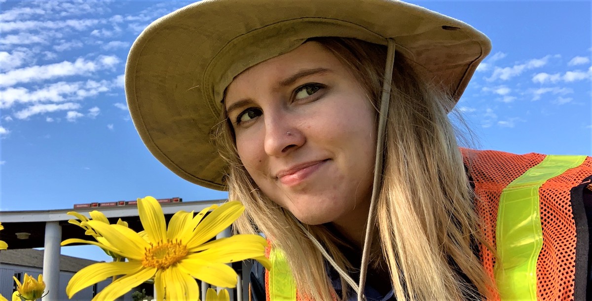 IAP Brooke Wilder admiring the spring bloom while removing invasive plants with the Weed Warriors.