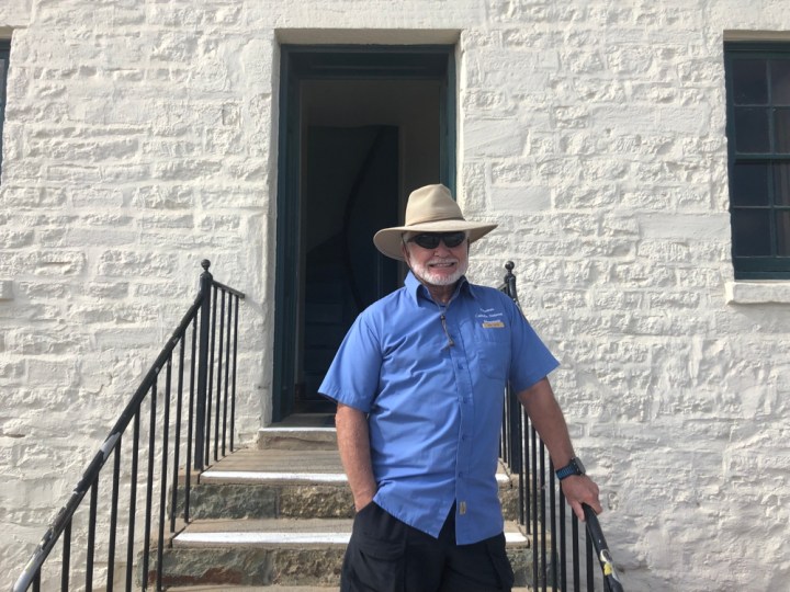 VIP Tony stands smiling and leaning on the railing leading up to the Old Point Loma Lighthouse.