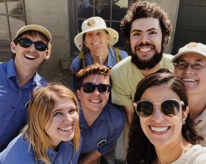 From left to right, VIPs Wyler, Brooke, Ryan, & Jose with CVA Setareh and TPERP Coordinator Pauline gather closely together outside of a military bunker on Bayside Trail to smile and pose for the camera.