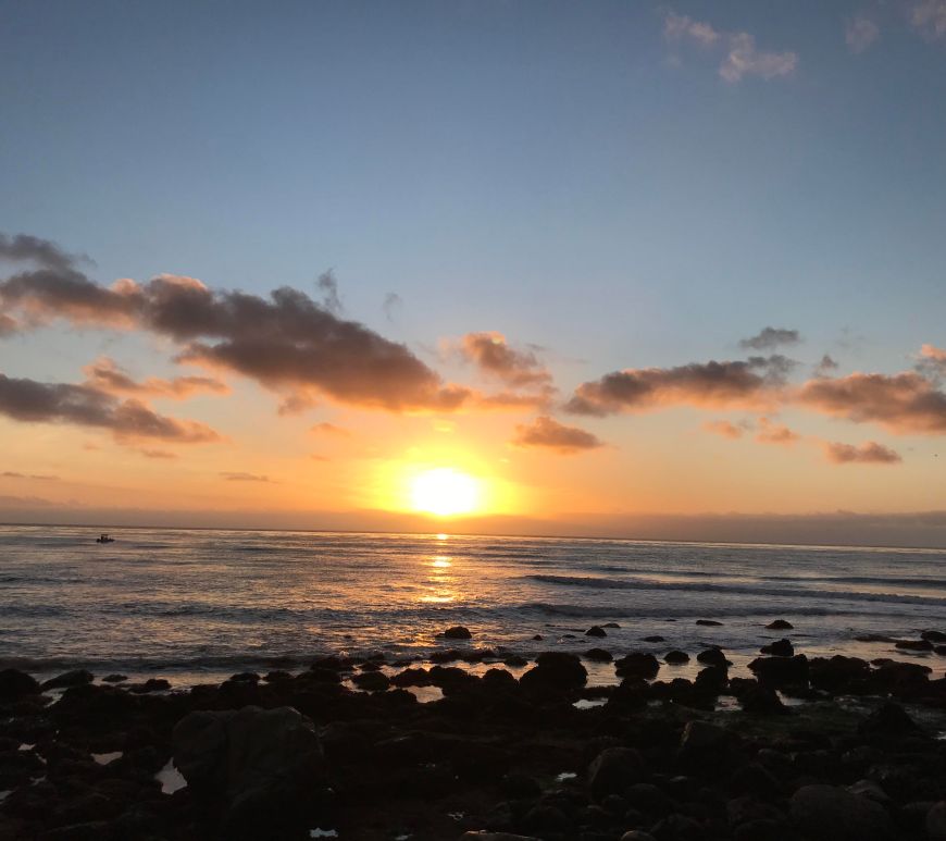 A sunset along a rocky shoreline.