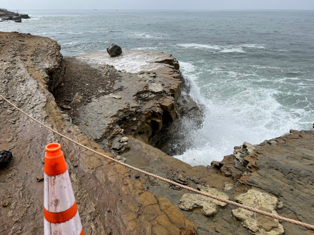 High surf from ocean hitting cliffs breaking off chunks of rock