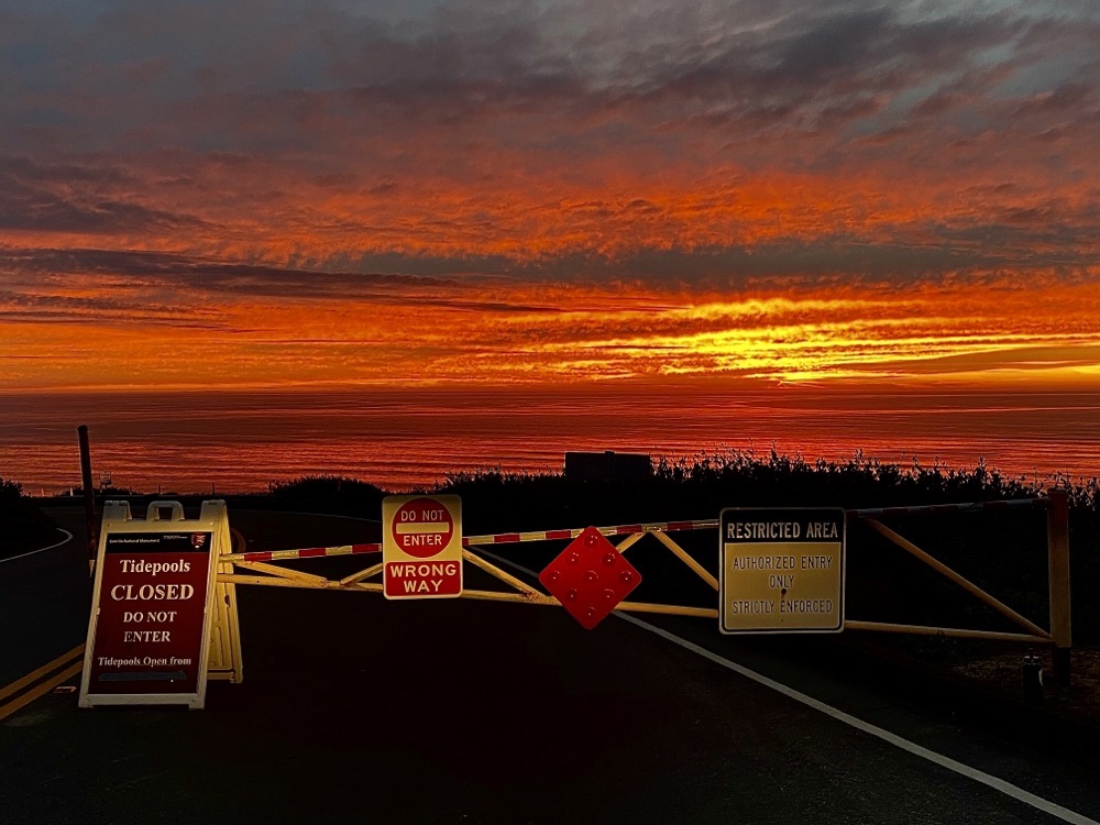 A sunset with orange clouds over the ocean