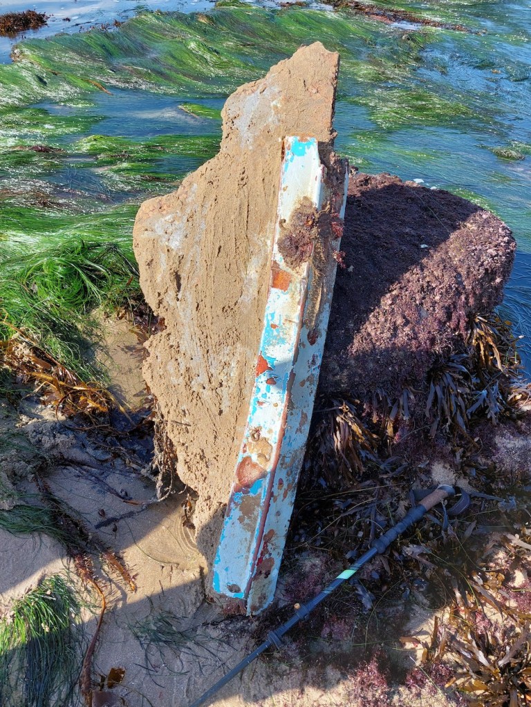 A piece of a boat that broke apart in the ocean.