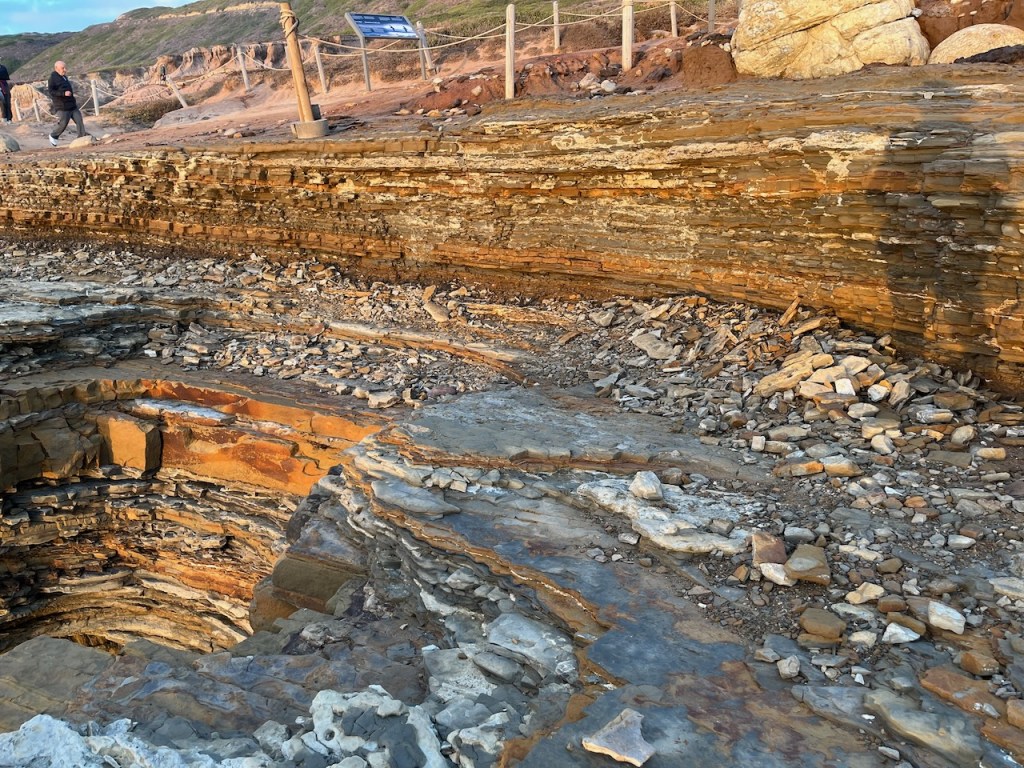 Broken pieces of rock scattered next to a cliff.