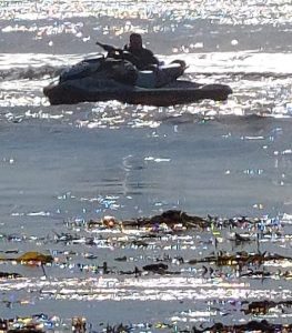 A person on a jet ski is stuck on shallow water.