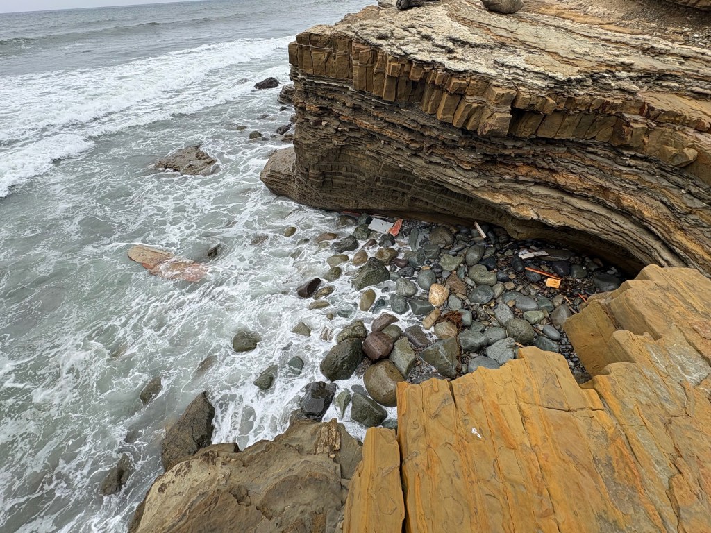A rocky coastline with waves crashing against the shore.