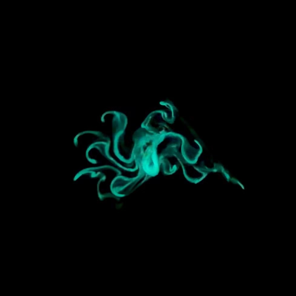 A swirl of glowing blue-green smoke curls and twists against a completely black background, resembling abstract, flowing tendrils.